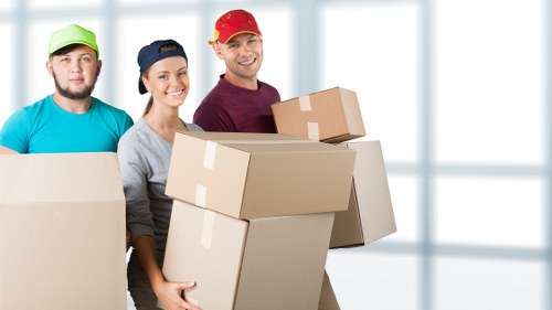 House movers handling furniture in a West Harrow family home