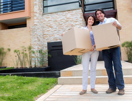 Movers carrying furniture through a narrow staircase in a local property